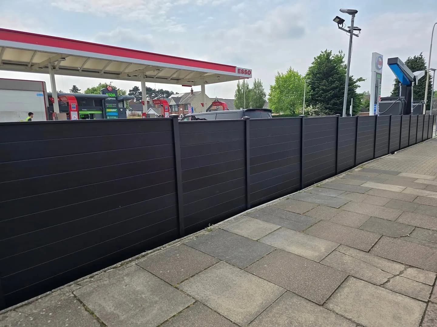 Long run of anthracite aluminium fencing along a forecourt footpath